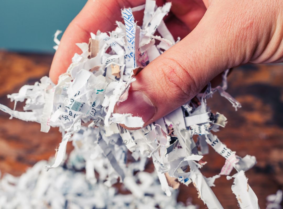 a person holding shredded papers