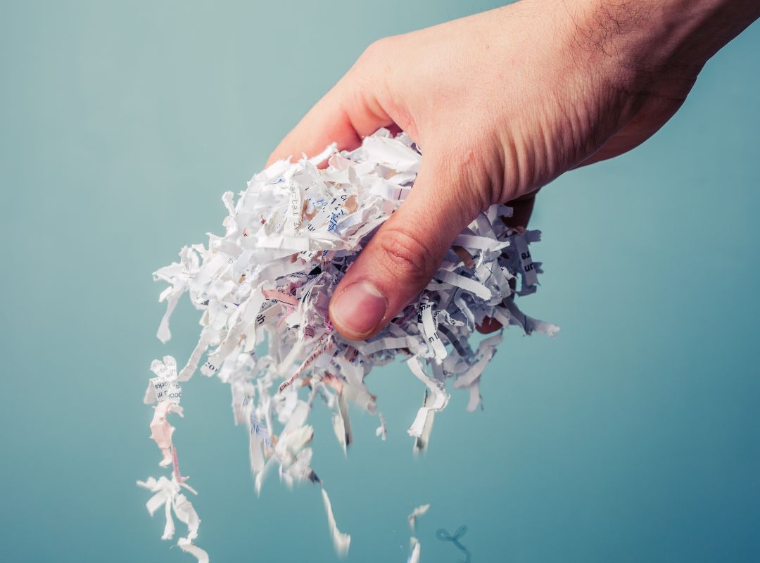 a person holding shredded paperwork